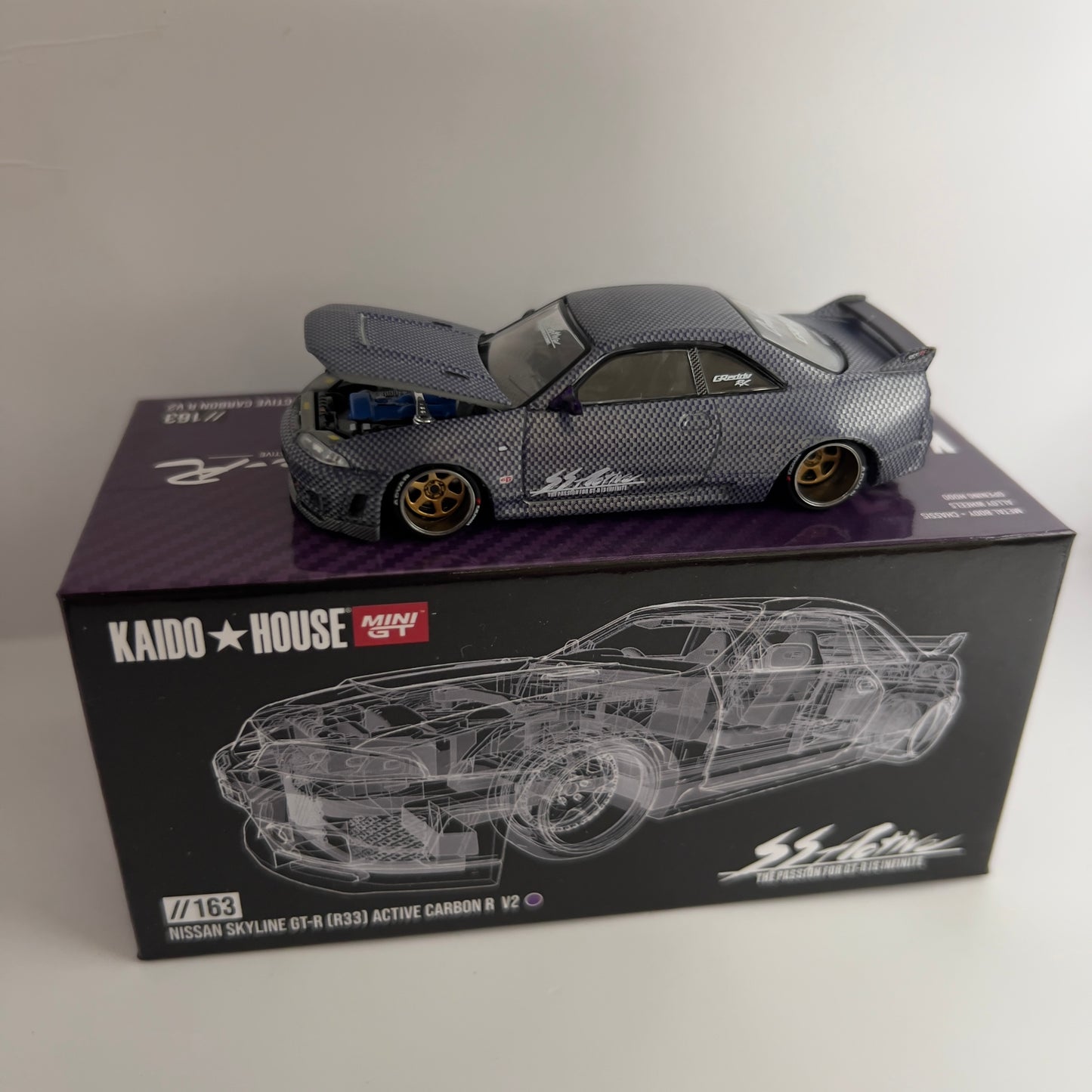 Mini GT x Kaido House Nissan Skyline R33 GTR Active Carbon Chase #163