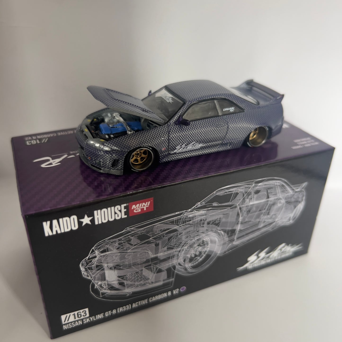 Mini GT x Kaido House Nissan Skyline R33 GTR Active Carbon Chase #163