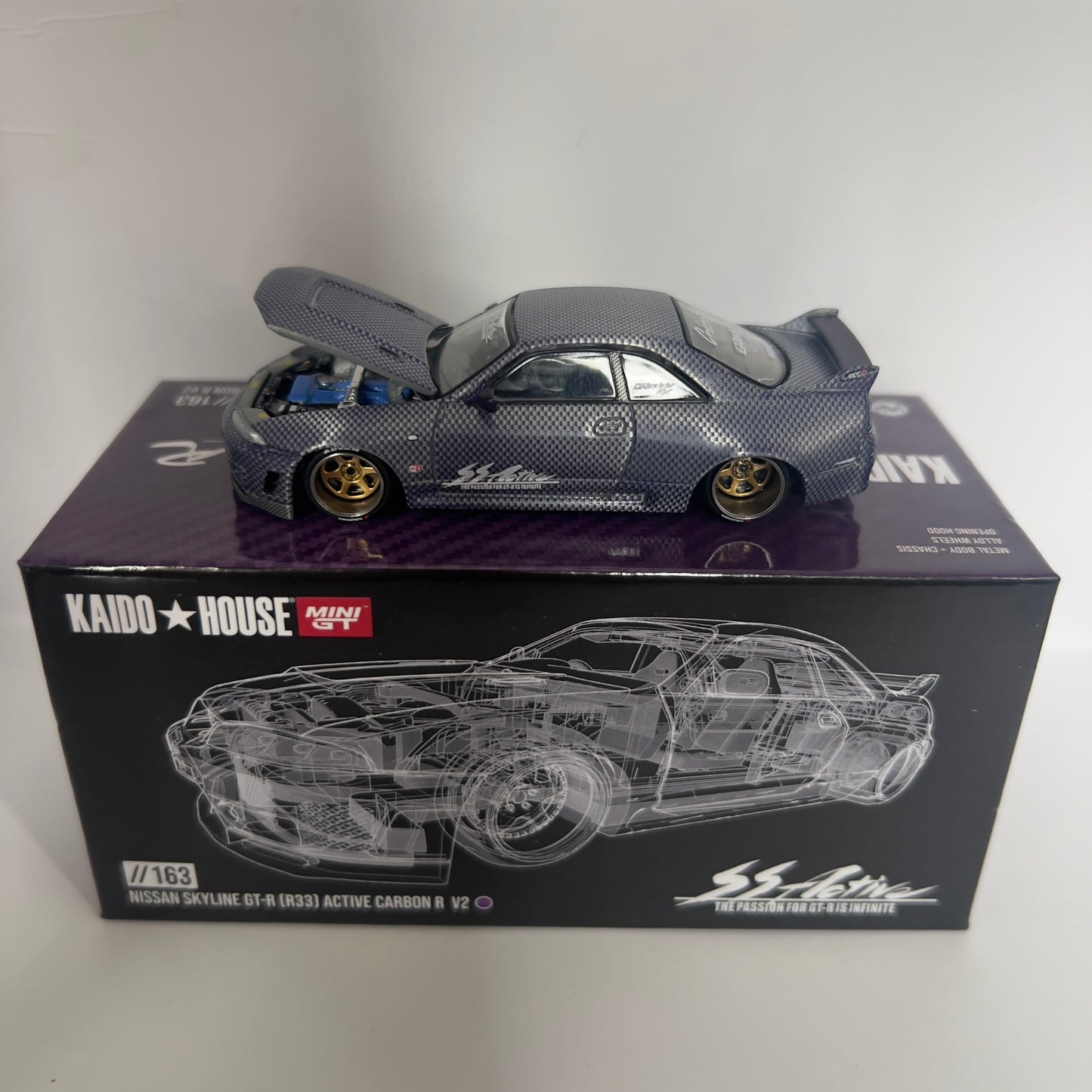 Mini GT x Kaido House Nissan Skyline R33 GTR Active Carbon Chase #163